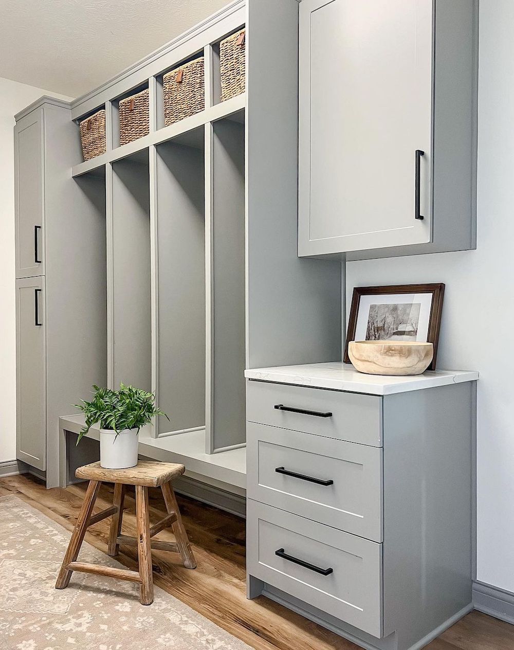 a soft grey mudroom with storage cubbies for different family members