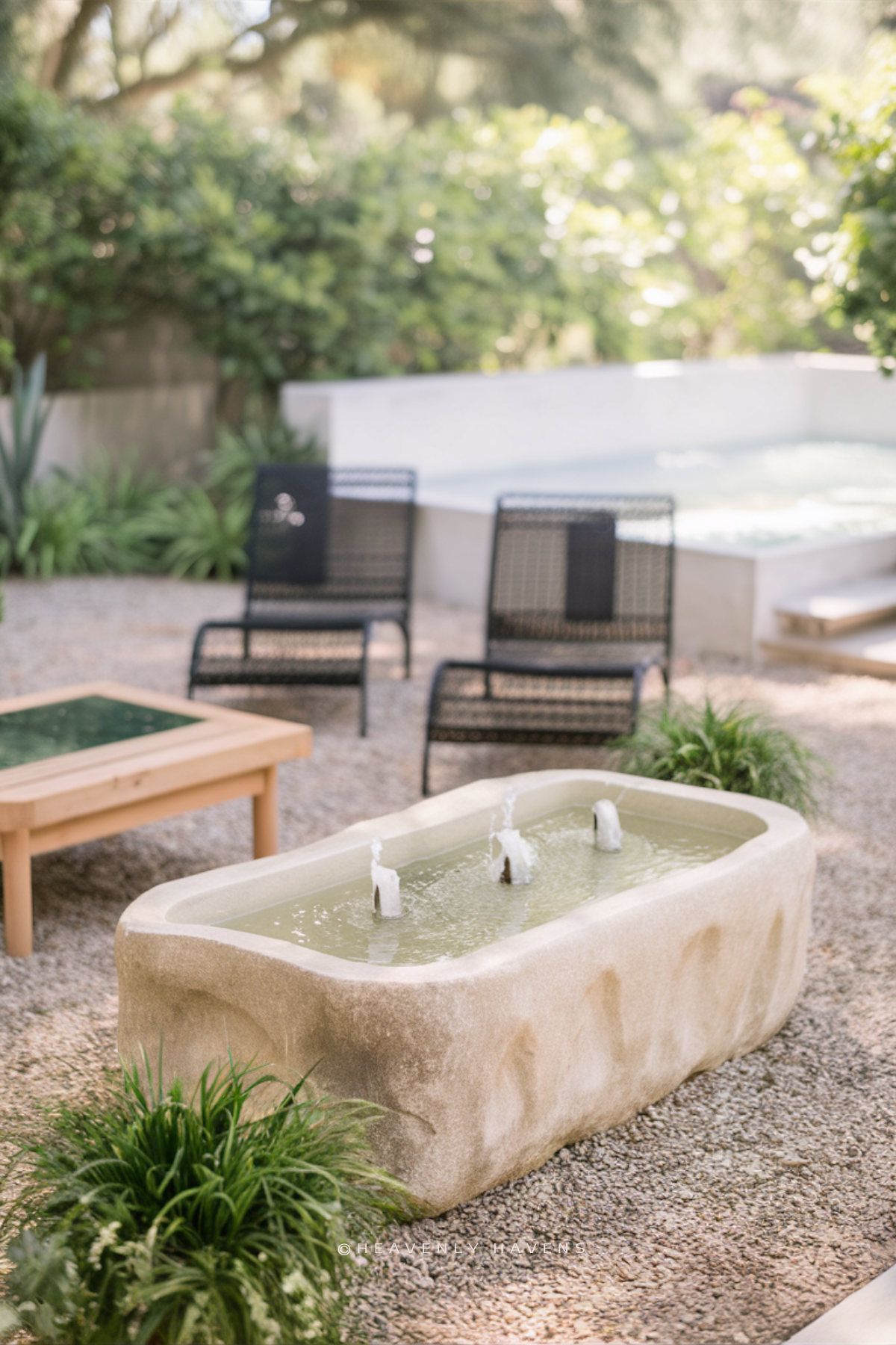 a backyard with lounge chairs and a small fountain