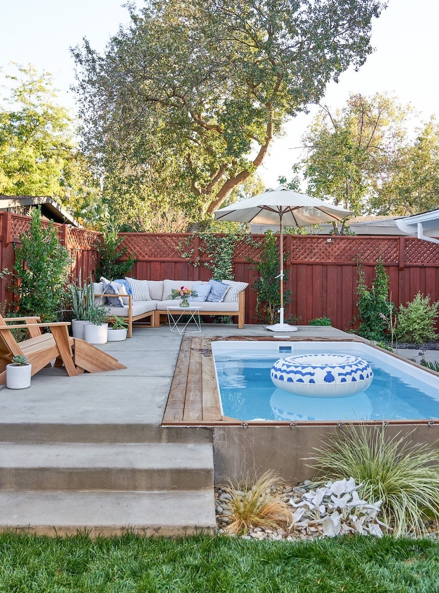 a backyard patio with a small pool and lounge seating