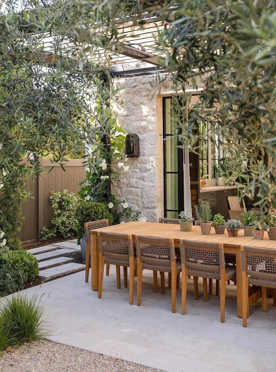 a backyard patio with a dining table and pergola