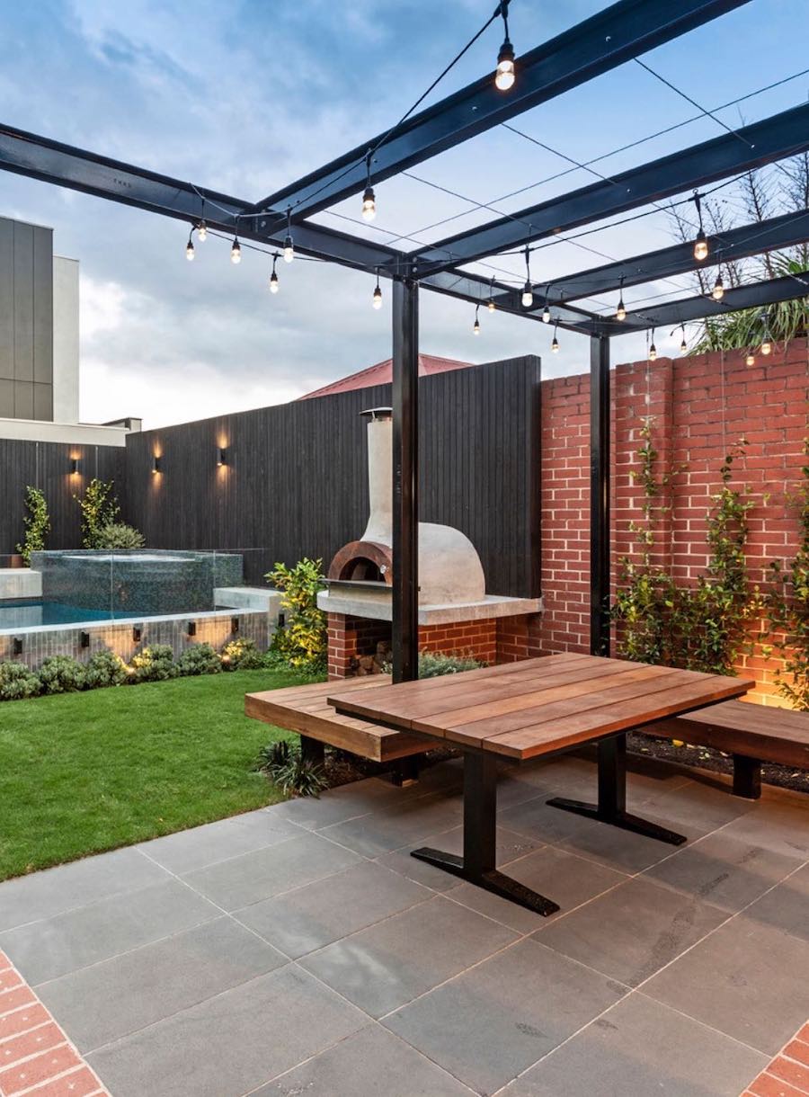 a backyard with a pool and hot tub, a fireplace, and a dining table