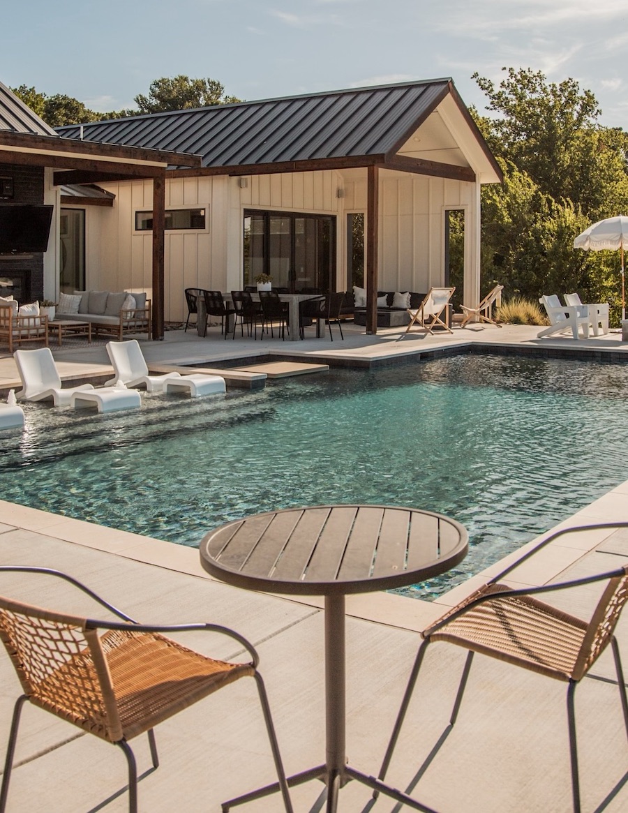 a backyard with a pool and lounge areas