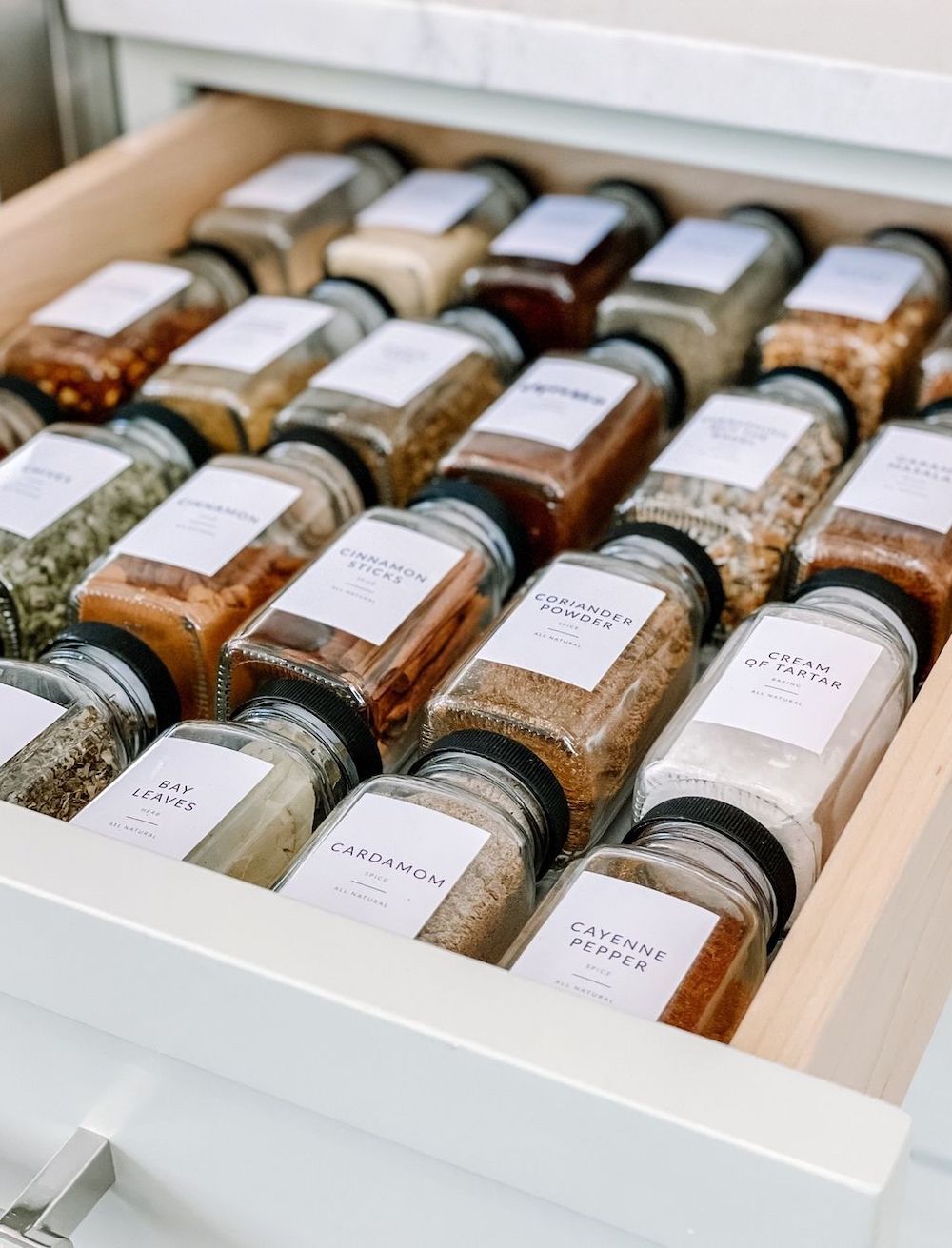 a spice drawer with matching labeled spice containers