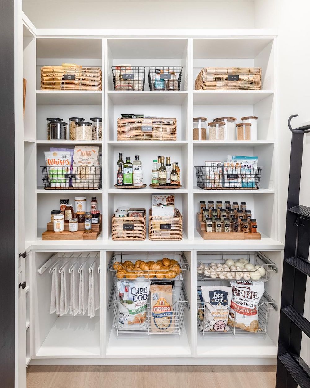 a pantry with built in shelving, pull out produce baskets, and wire and wicker baskets