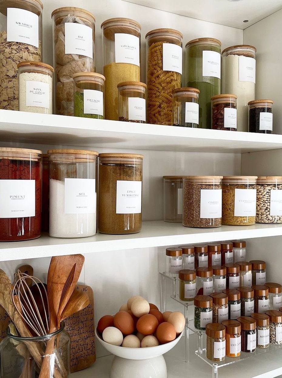 a pantry with glass canisters and a spice stand