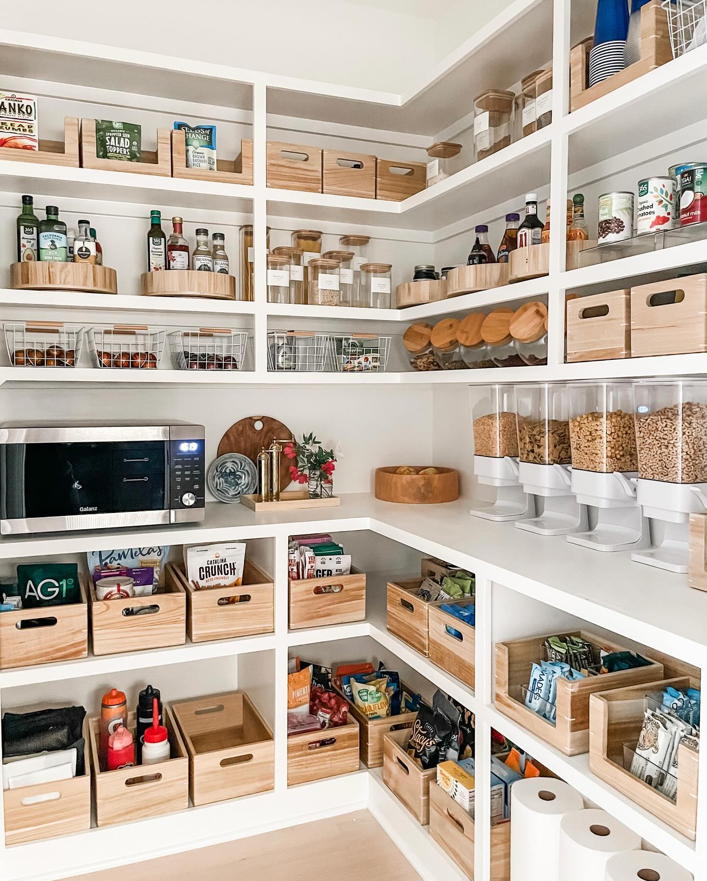 a white pantry with wooden bins and wire baskets for organization